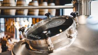 Close-up of a shiny brewing kettle with a viewing window and the brewery logo at the Liechtenstein Brewery