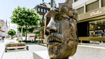 A modern bronze sculpture of a face in the old town of Vaduz
