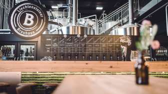 A view of the stylish tap system and the brewery area with its stainless steel tanks and industrial design.